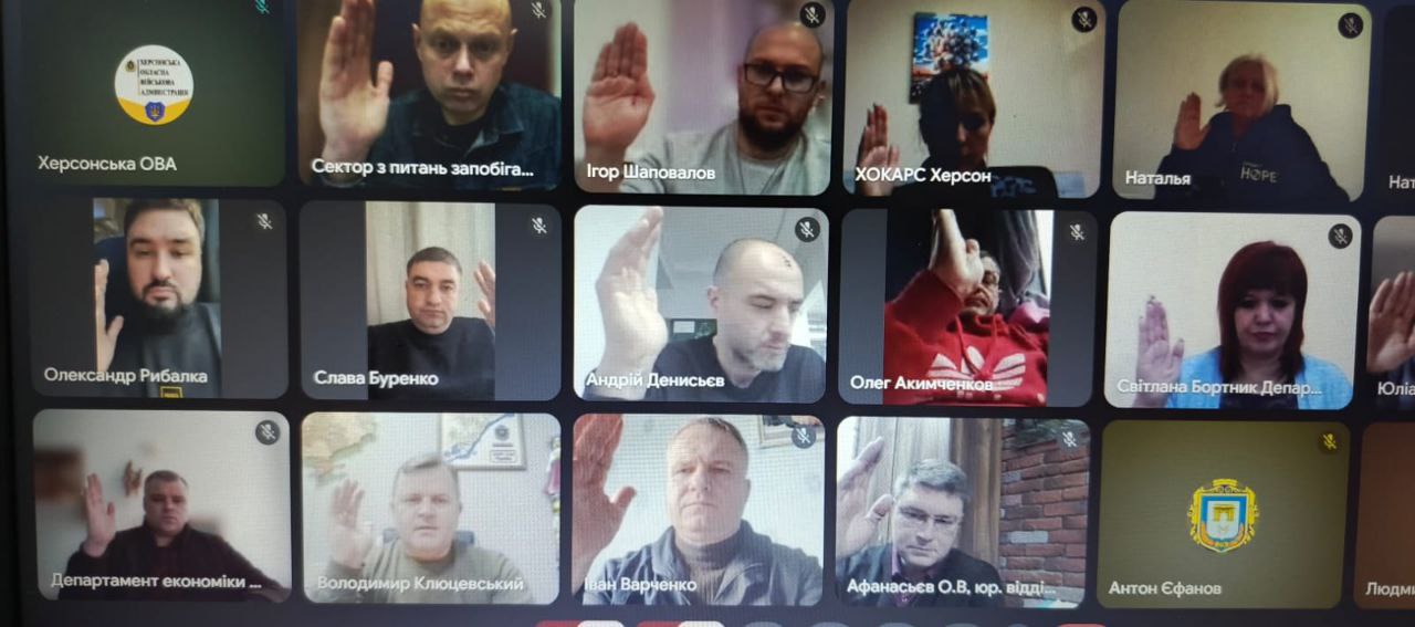 Знімок екрана онлайн-зустрічі (відеоконференції), на якому видно сітку з 15 учасників. Більшість людей підняли праву руку під час голосування. На екрані видно імена учасників та назви організацій, такі як: Херсонська ОВА та ХОКАРС Херсон.