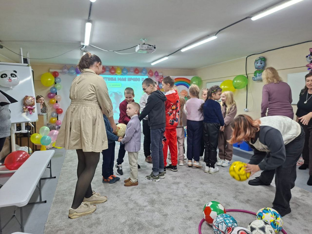 Великий плакат із малюнком, що зображує двох усміхнених мультяшних дітей під яскравою веселкою, іграшки (м'яч, повітряний змій) та напис великими червоними літерами: Всесвітній день дитини. У правому верхньому куті видно логотип і напис: ХЕРСОНСЬКА ОБЛАСНА ВІЙСЬКОВА АДМІНІСТРАЦІЯ.
