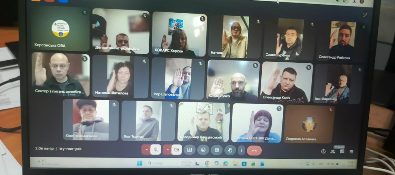  Екран ноутбука, на якому зображена онлайн-конференція (відеозустріч) за участю близько 18 осіб. Більшість учасників, включаючи представників Херсонської ОВА, підняли праву руку.
