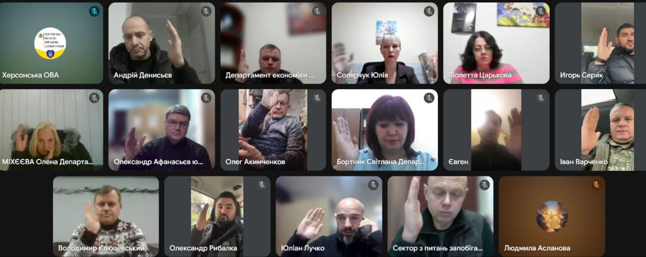 Скриншот онлайн-наради у форматі відеоконференції, на якому видно плитки з багатьма учасниками. Більшість присутніх одночасно підняли руки для голосування або привітання; серед віконець також видно логотип Херсонської ОВА.