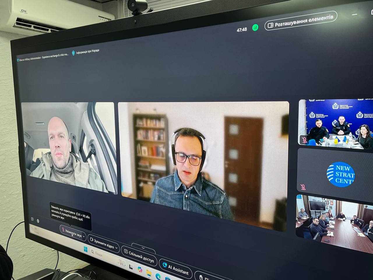 Екран монітора з вікном відеоконференції, де відображено декілька учасників онлайн-наради та панель керування дзвінком.