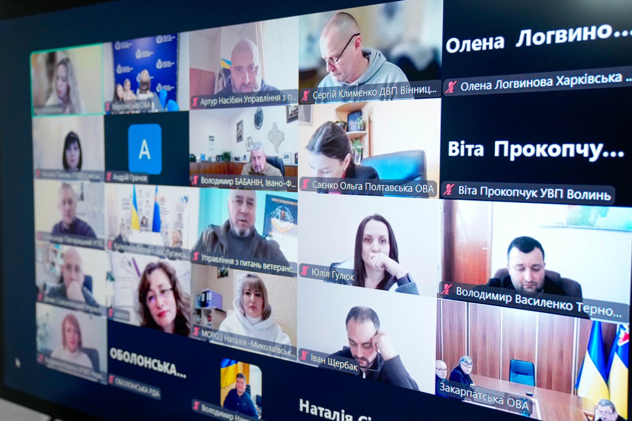 Екран монітора, на якому відображено онлайн-конференцію у форматі відеозв'язку. Видно численні вікна з учасниками зустрічі, а також підписи з іменами та назвами обласних військових адміністрацій різних регіонів України.