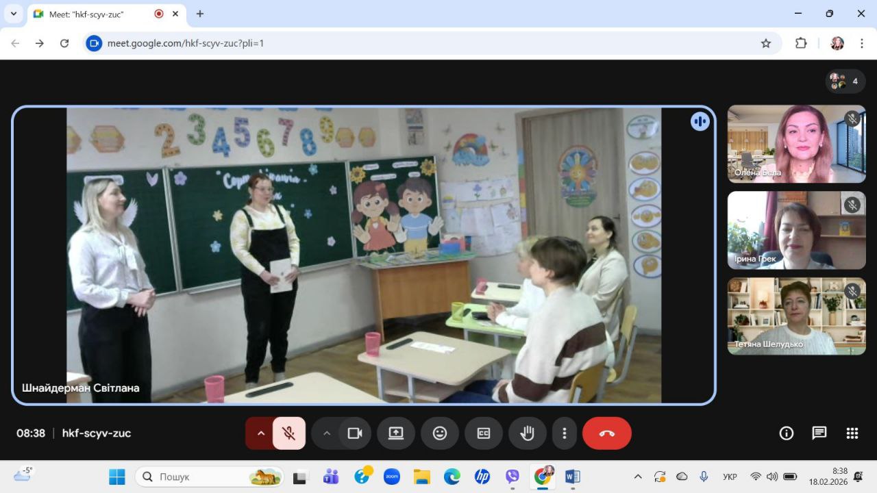 Скриншот відеозустрічі, на якій транслюється урок у класі з двома вчителями біля дошки та вікнами учасників збоку.